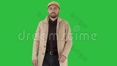 时尚男人，深色胡须，穿着风衣，走在绿色屏幕上，Chroma键。